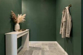 Entrée moderne avec mur vert forêt profond, console en chêne blanc et accessoires en laiton brossé sur carrelage gris clair