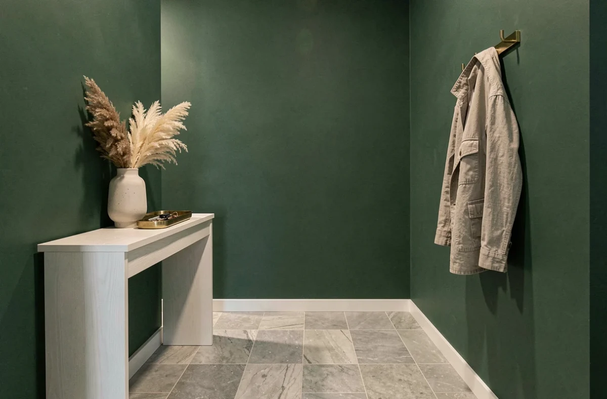 Entrée moderne avec mur vert forêt profond, console en chêne blanc et accessoires en laiton brossé sur carrelage gris clair